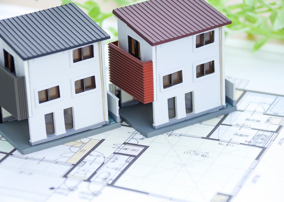 建築図面と住宅模型を使って工事提案を行うイメージ写真