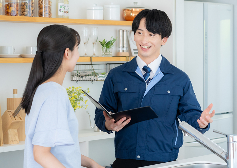 キッチンで設備説明を行うスタッフとお客様